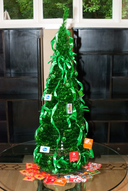 green giving tree on a table surrounded by gift cards on the table underneath it
