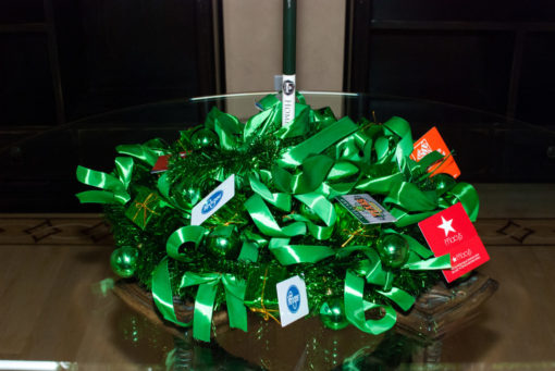 green giving tree with gift cards collapsed on a glass table ready for packing